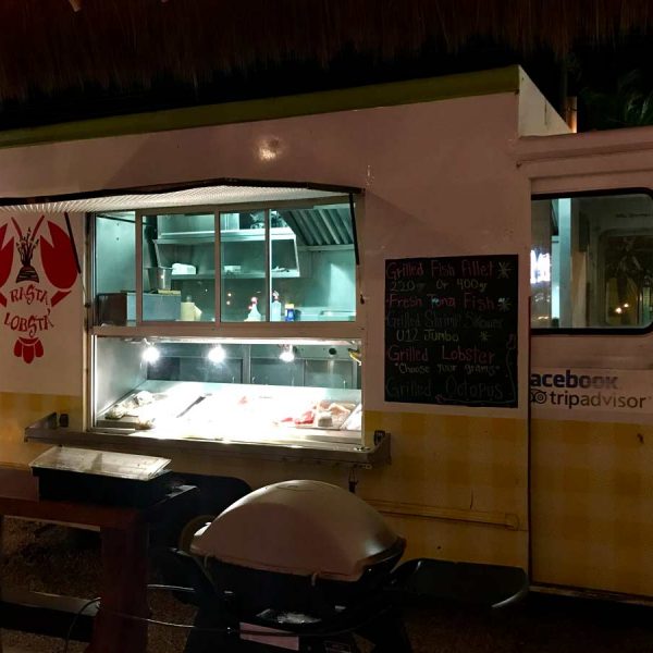 a white and yellow food truck is open for business on the streets of Puerto Morelos