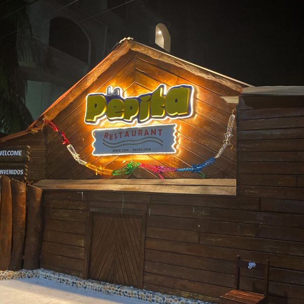 the enterance to la pepita restaurant displays a lighted sign at night
