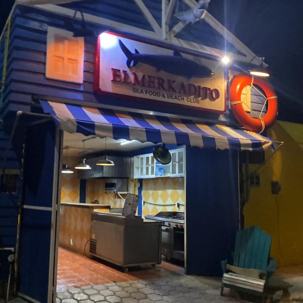 a blue building decorated with a large life perserver and fish welcomes hungry seafood lovers